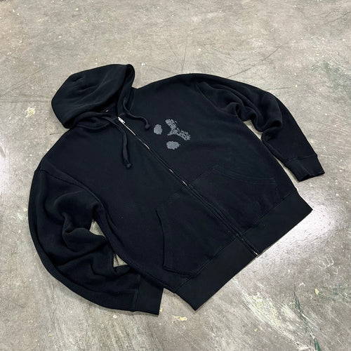 Black hoodie with floral design on a gray surface