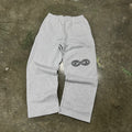 Gray sweatpants with a logo on a concrete floor