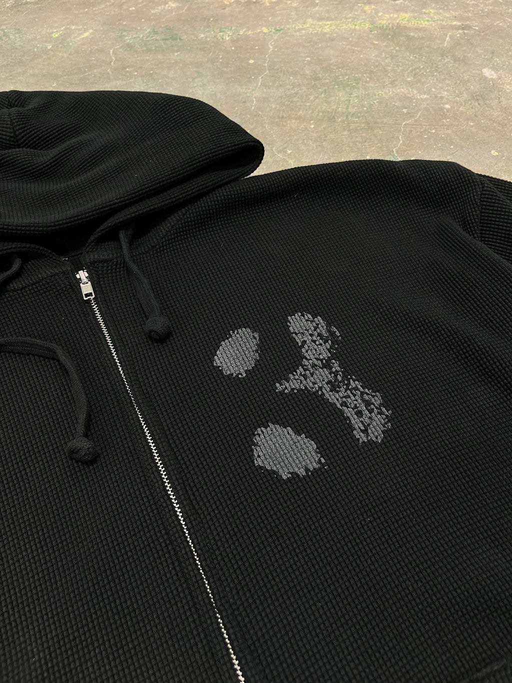 black hoodie on concrete floor